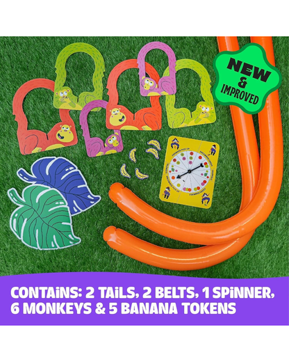 A colorful monkey-themed game set laid out on green artificial grass, including orange tails, multiple colored monkey-shaped belts with banana face details, a yellow spinner card, banana tokens, and two tropical leaf-shaped items. A green badge says 'NEW & IMPROVED,' and a purple text bar at the bottom lists included pieces.