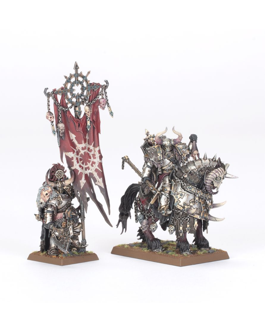 Two painted Warhammer miniature figures on a white studio background: a heavily armored warrior holding a large red banner with a white emblem, and a silver armored rider on a horned beast mounted on a base.