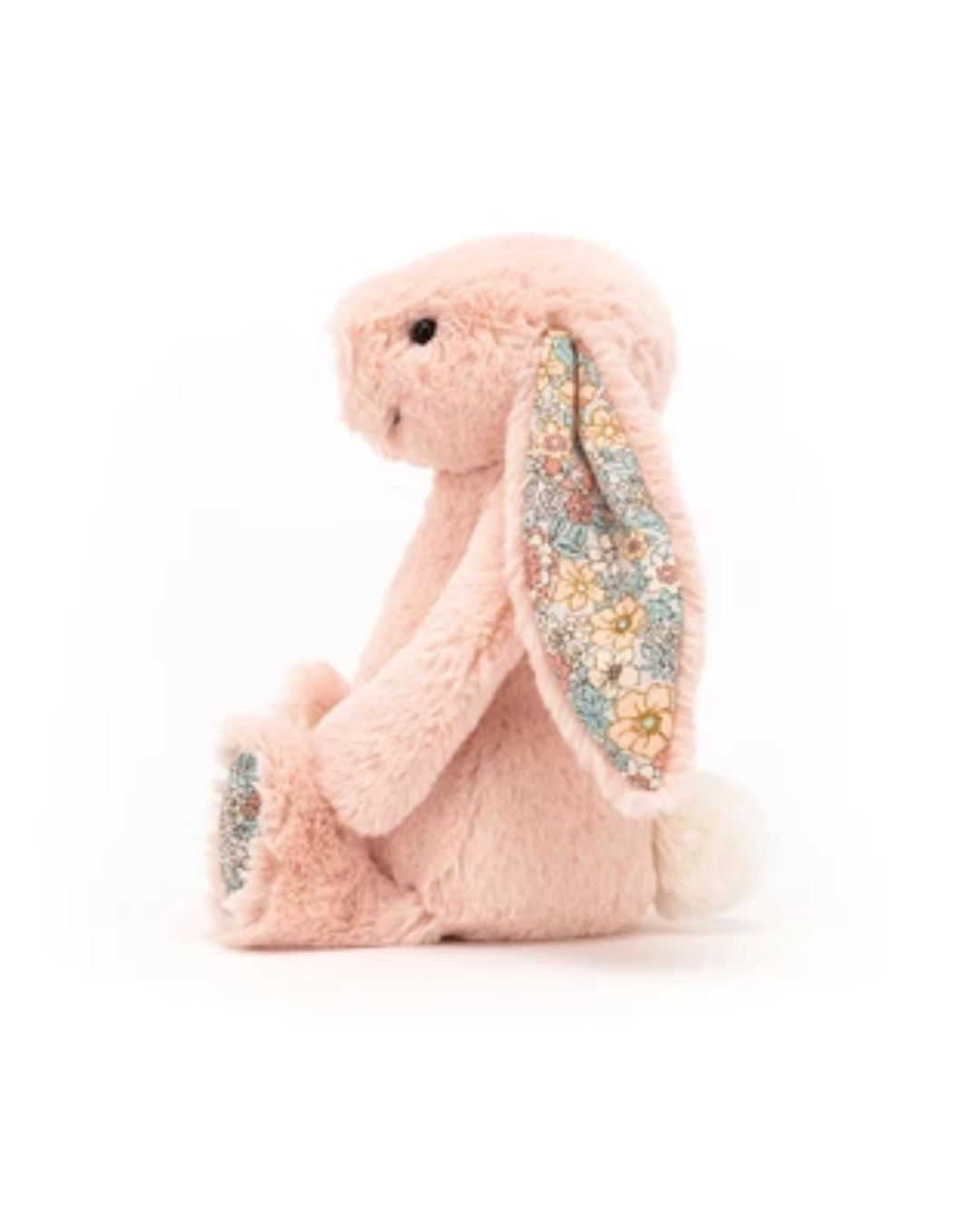 A pink plush bunny toy with long floppy ears featuring a colorful floral pattern, sitting on a white background.