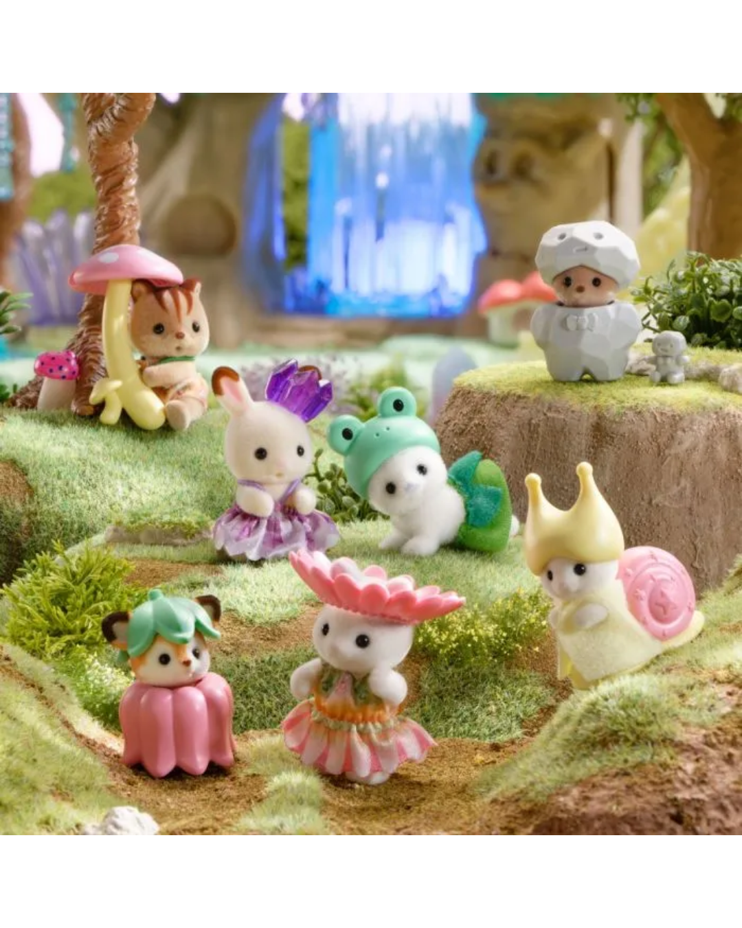 Collection of small figurines in a garden setting with trees and grass.