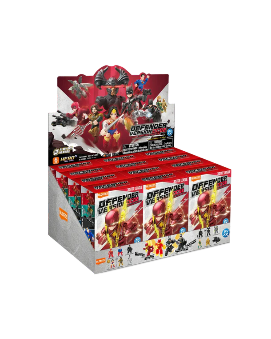 A retail display box filled with DC Justice League Defender mini-figures, featuring red and white packaging with DC Comics characters on a white background.