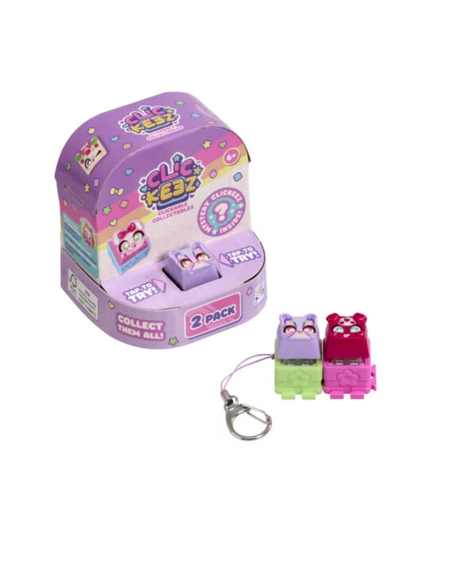 A 2-pack of Clickeez collectible keychains shown with their purple display packaging box. The keychains include a purple cat in a green bed and a pink cat in a red bed, both attached to silver keyrings.