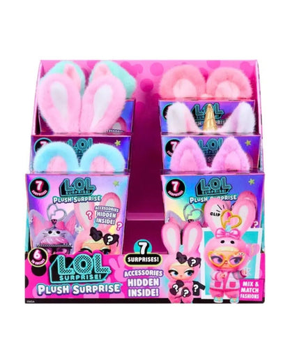A retail display box filled with multiple LOL Surprise! Plush Surprise toy packages, each containing plush bunny ears and a hidden surprise figure. The display is pink and purple with colorful packaging, shown on a plain white background.