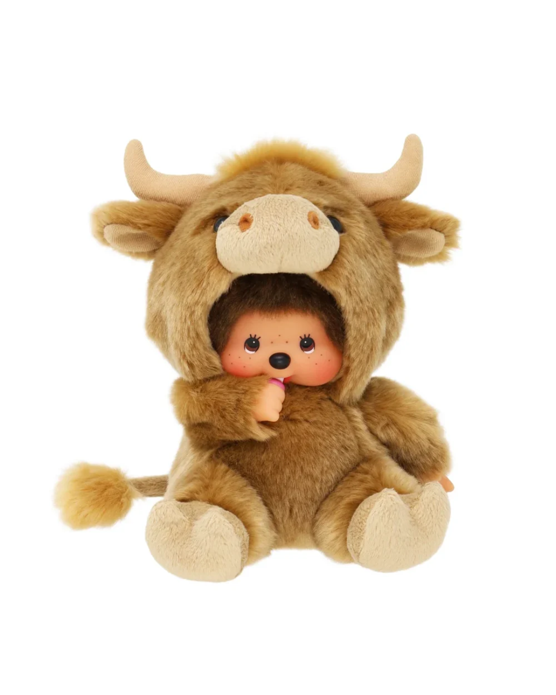 A Monchhichi featuring a brown and beige bull costume hood with horns, enclosing a small doll with dark hair, pink cheeks, and a black nose, isolated on a white background.