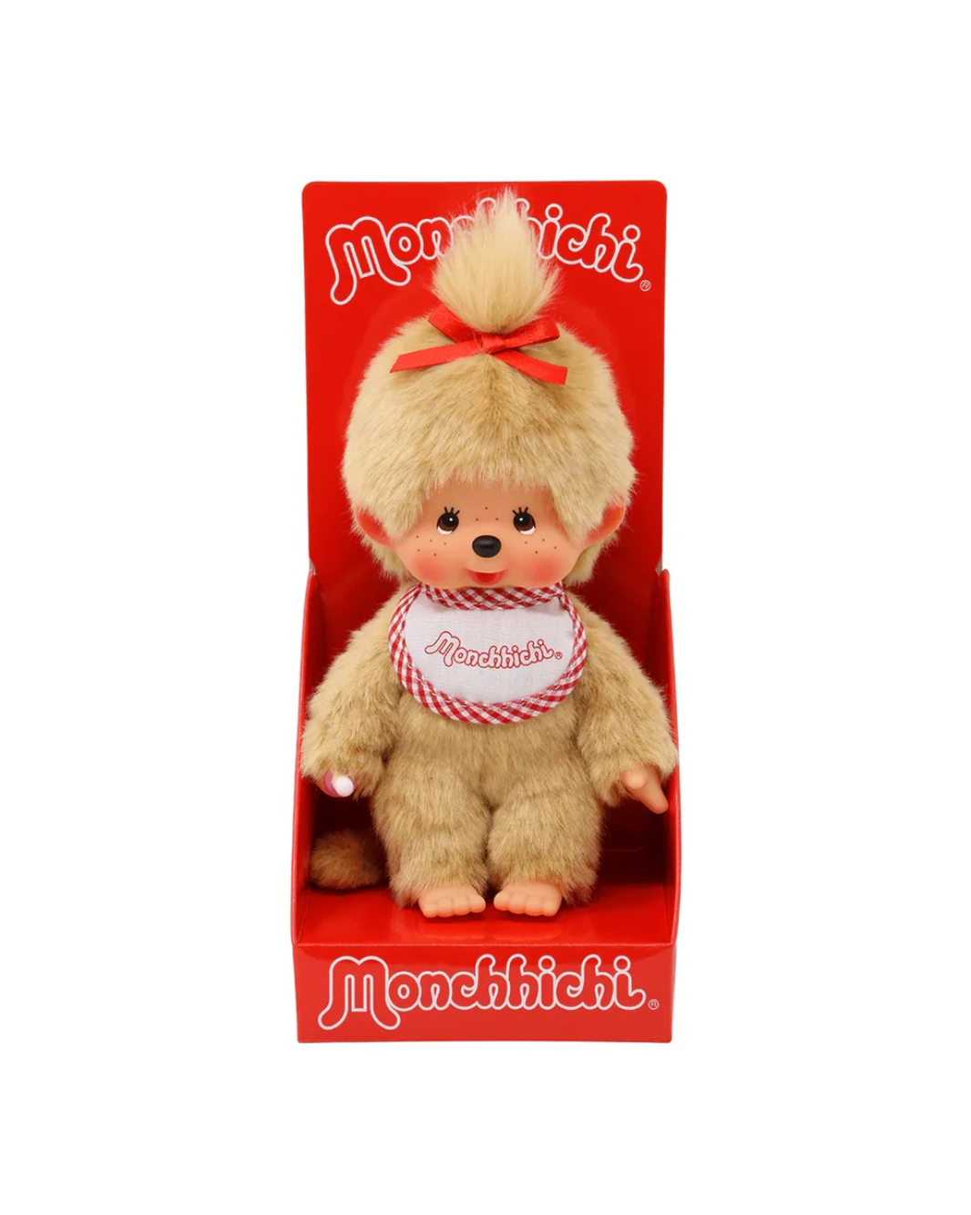 A Monchichi plush toy doll with light brown fur, a red bow, and a red-and-white checkered bib, displayed inside a red retail box with the Monchichi brand name.