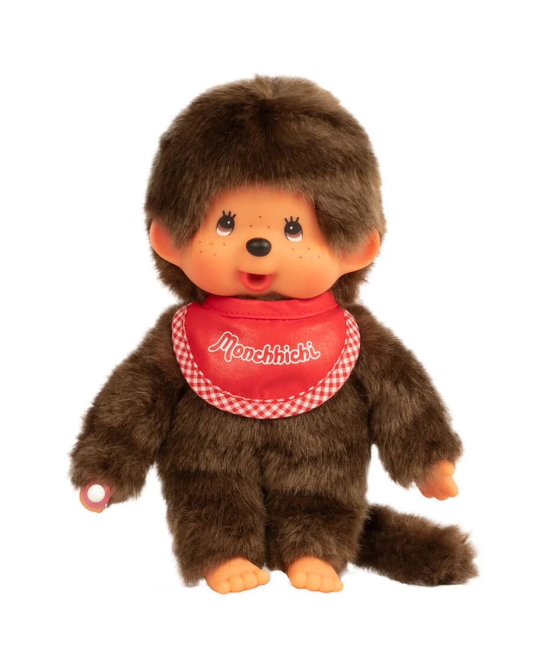 A classic Monchichi monkey plush toy with brown faux fur, an orange face, and a red bib with white script reading 'Monchichi'.