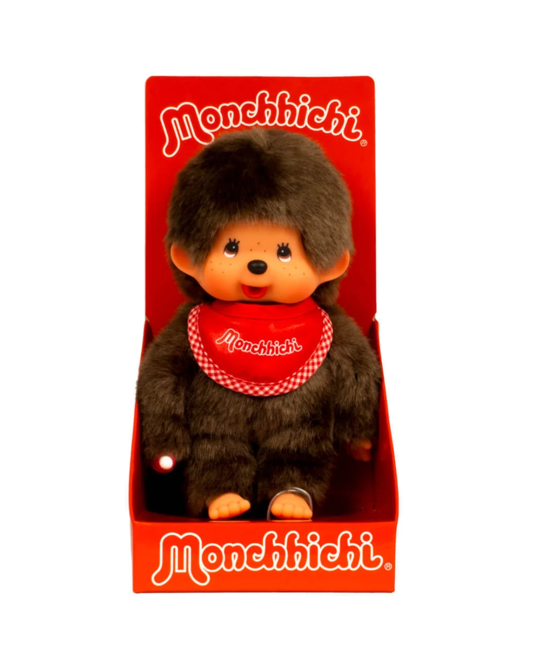 A Monchhichi toy monkey doll sitting inside its red retail box, with the Monchhichi brand name printed in white on the red packaging.