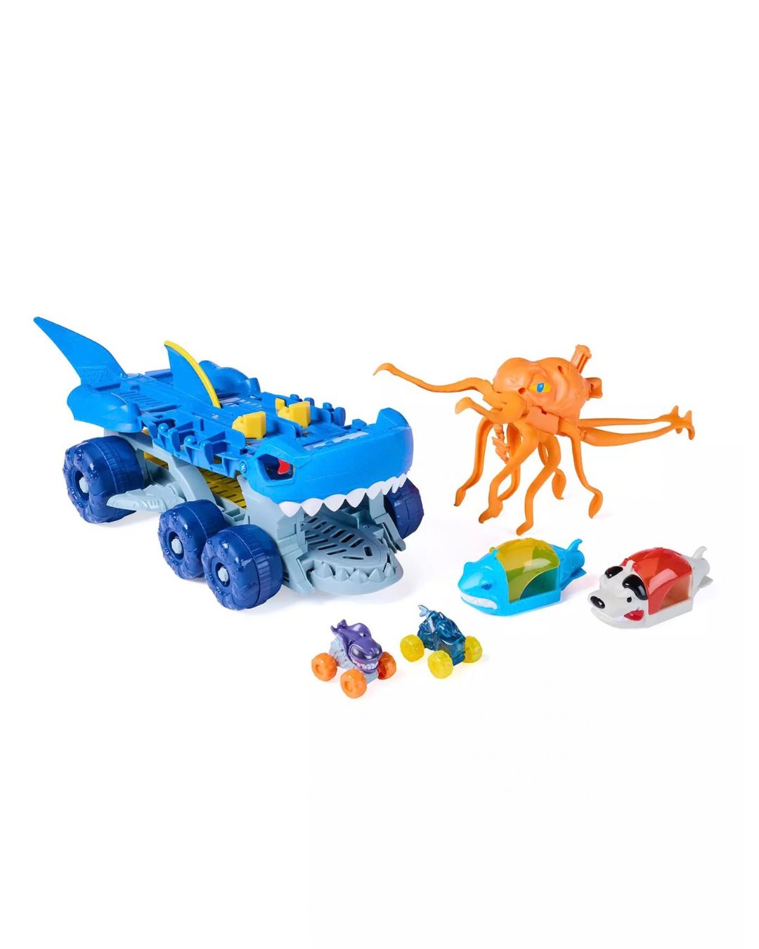 
Monster Jam: Mini James Feature Carrier packaging box featuring a blue shark-shaped vehicle with wheels, an orange octopus, a small blue and yellow boat, two small toy cars, and a red-and-white dog figure, all arranged on a plain white background.
