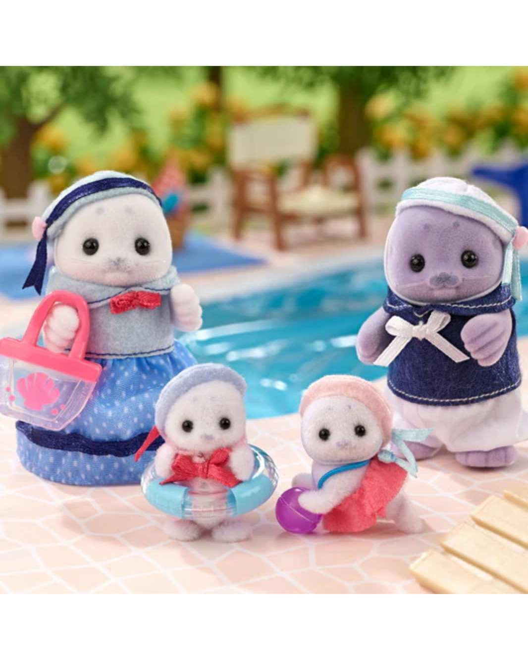Sylvanian Families Seal Family of four  wearing marine themed outfits. The family contains  mother, father and two cubs. The figures are standing in front of a blurred background conaining a lake.