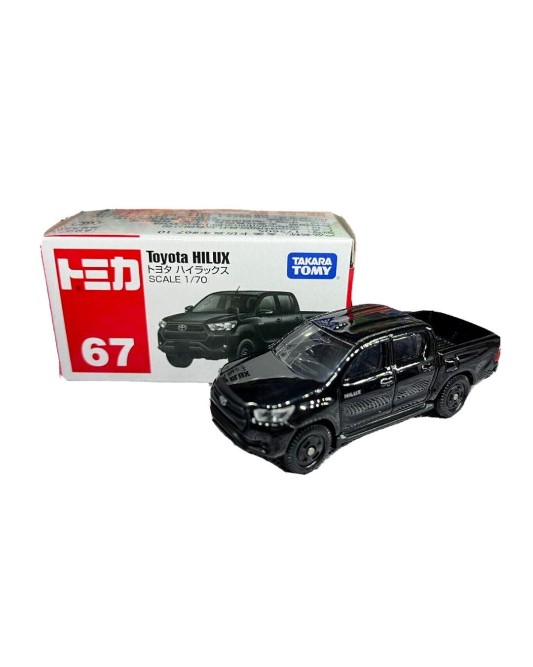 A black Tomica Toy Cars diecast model of a  1:70 scale, No. (67) Toyota Hilux pickup truck, shown next to its original box on a plain white background.