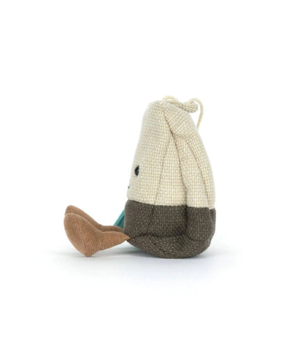 Knitted toy resembling a tea bag with a white body and brown fins on a white background
