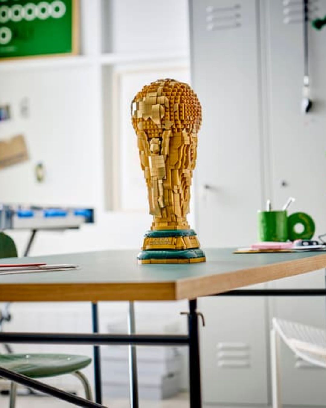 Large wooden sculpture on a table with a classroom setting in the background
